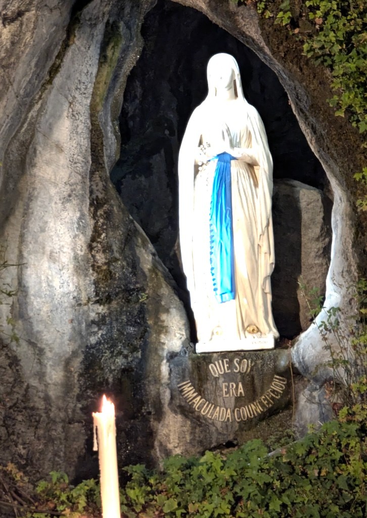 The grotto of Massabielle in Lourdes at night, lit by candles